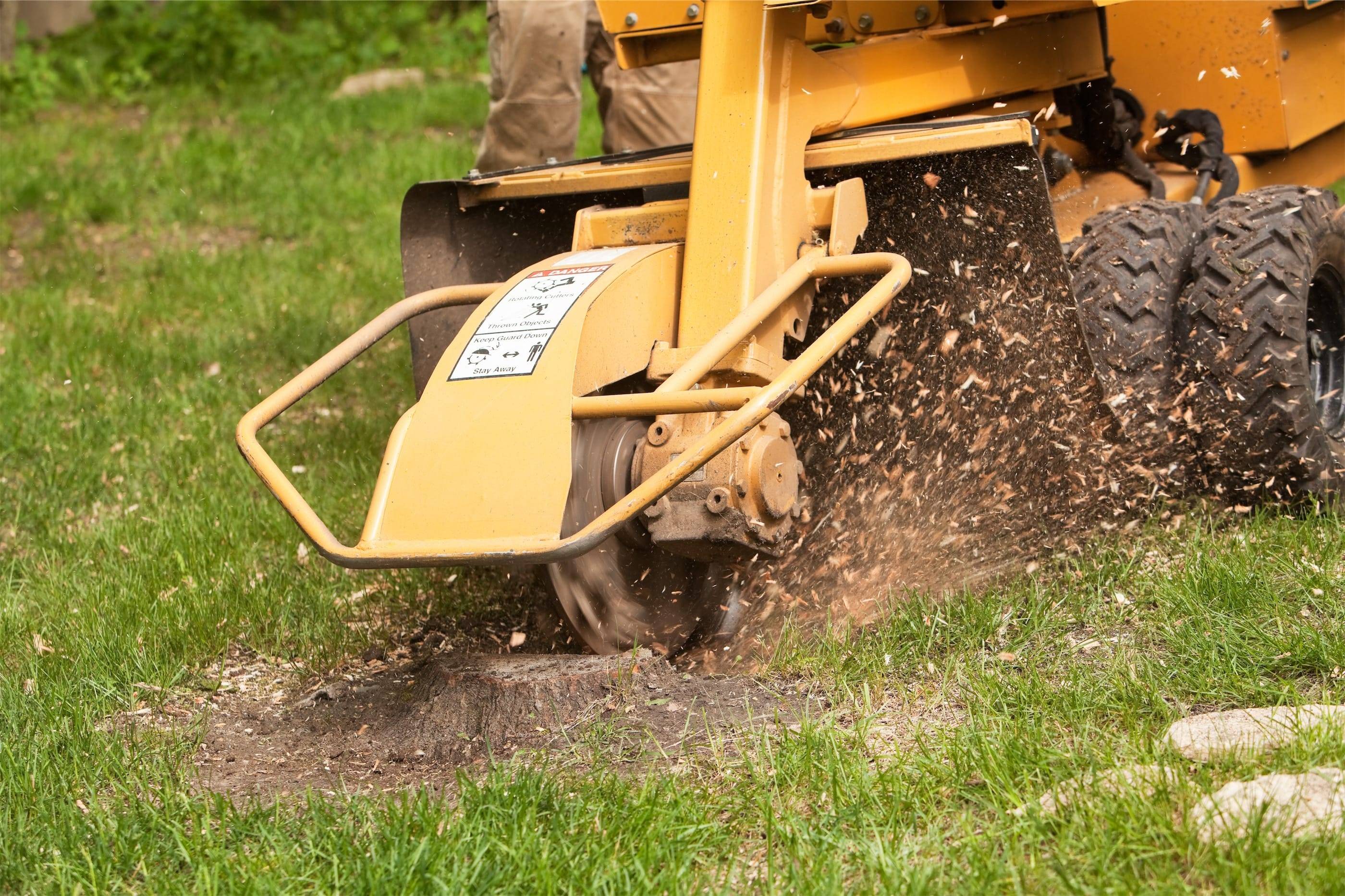 A person using a machine to dig a hole in the grass.