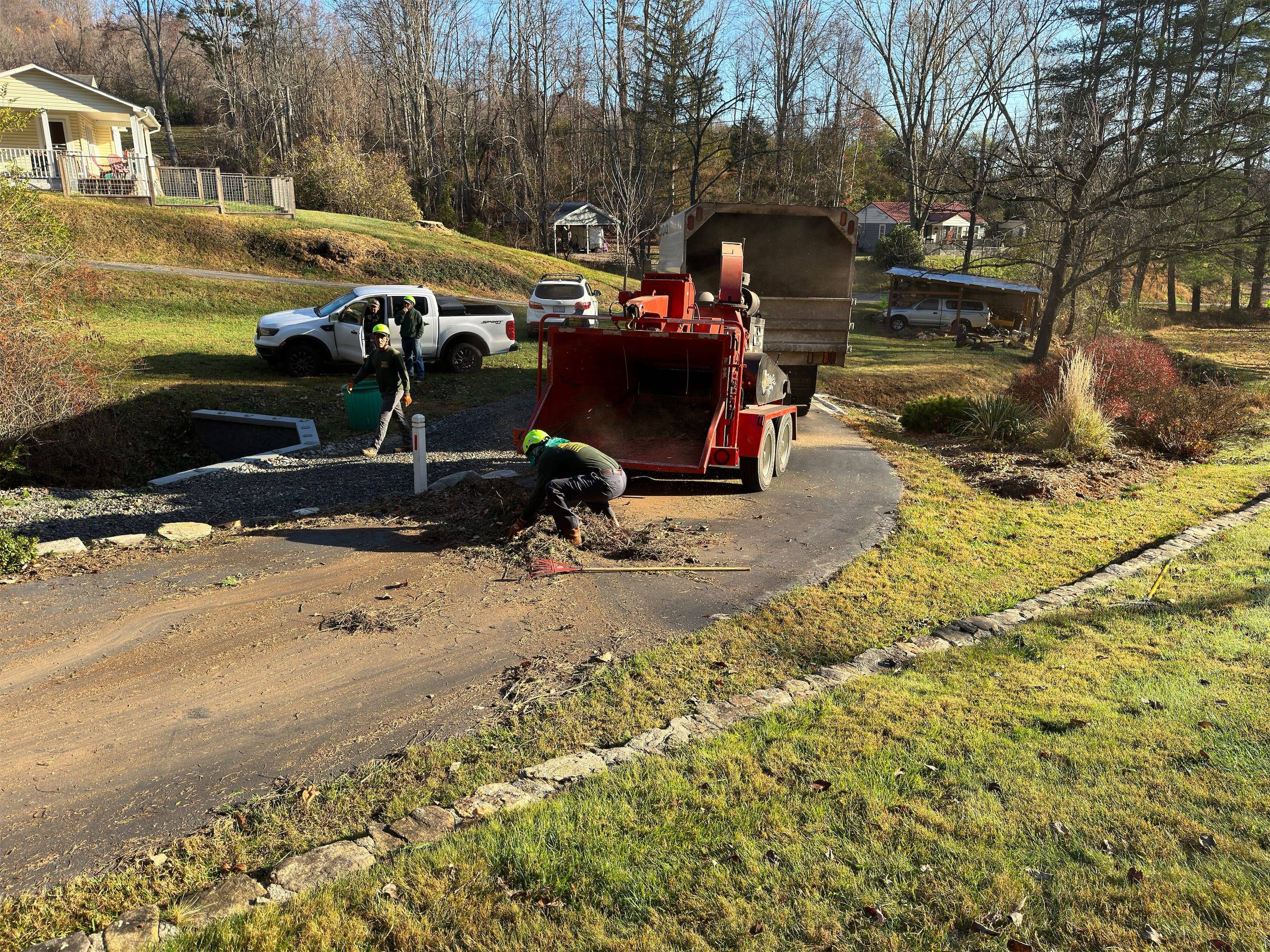 A man is working on a road in front of a house.